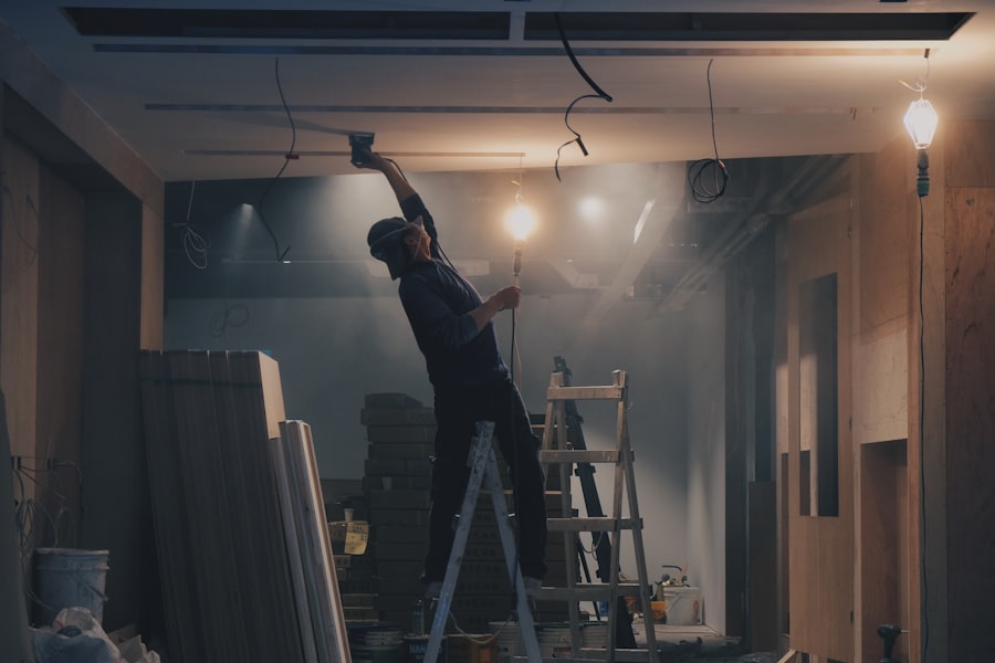 Contractor on a ladder finishing a ceiling during an interior renovation